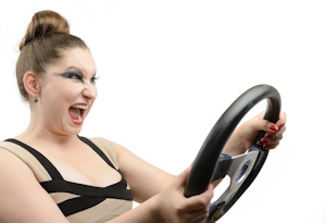 Emotional beautiful young girl with a steering wheel on white